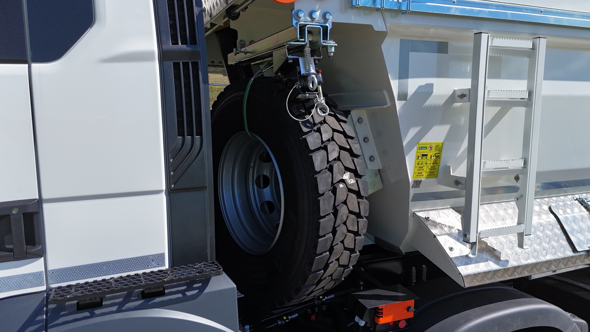 Spare-wheel holder sliding out away from the cab